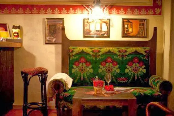 Maľovaný výklenok s ľudovým ornamentom a drevenou lavicou