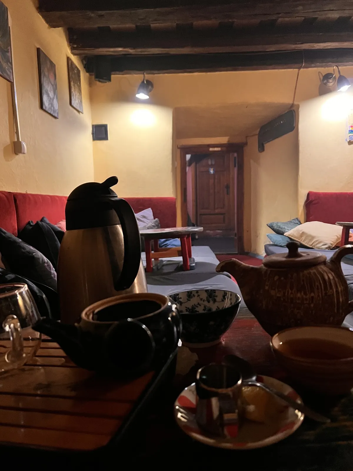 Chodba čajovne s tmavým trámovým stropom a samovarom